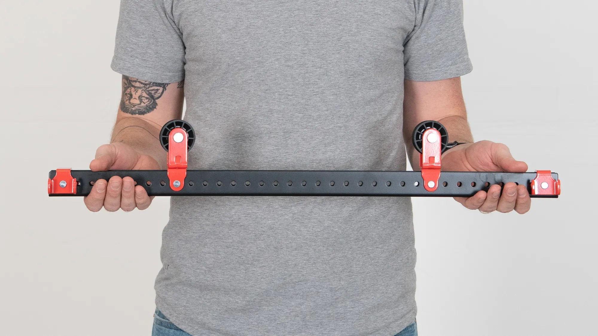 A man holding a red and black skateboard rack.